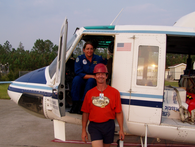 NOAA Corps woman helicopter pilot and civilian flying in support HurricaneKatrina damage evaluation and relief efforts