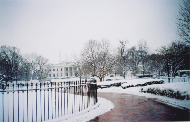 The White House draped in newly fallen snow with the Washington Monumentbarely visible in the background