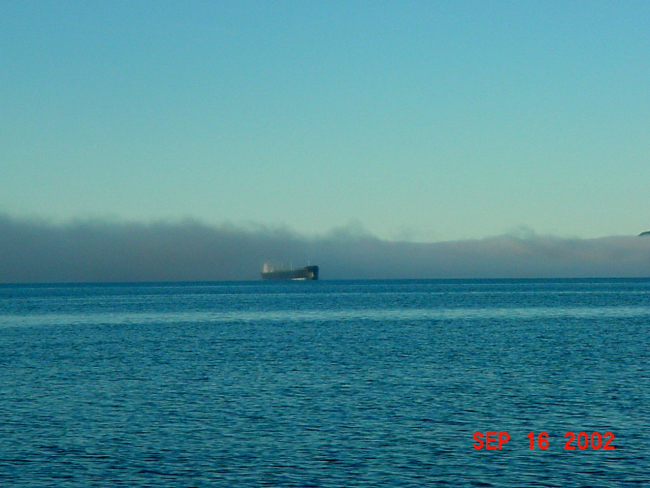A tanker passing out of a fog bank