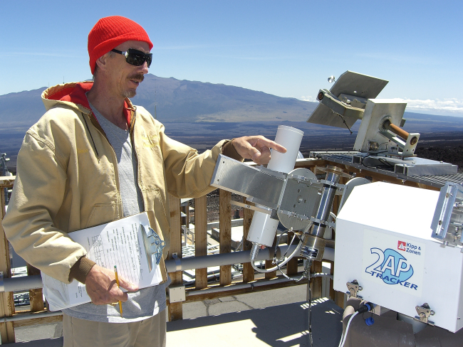 Steve Ryan points to an instrument that measures the intensity of sunlightat the Mauna Loa Observatory