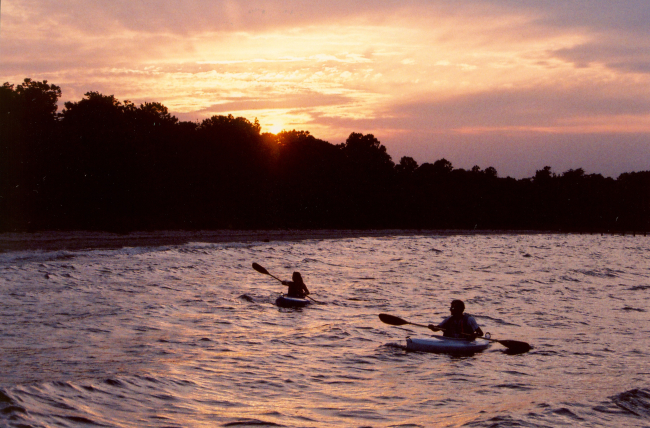 Kayakers enjoying a warm summer sunset
