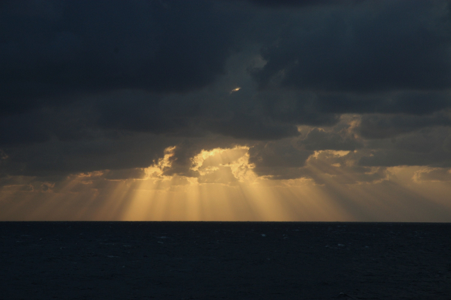 Glorious crepuscular rays terminating on the ocean surface