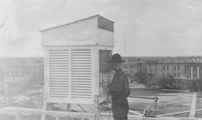 Signal Corps meteorological student Callen opening an instrument shelterin order to read thermometers