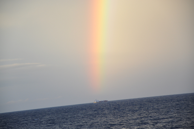 Rainbow over a small cargo ship