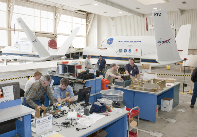 Atmospheric scientists check out their instruments in a hangar at NASADryden Flight Research Center prior to installation aboard one of NASA's twoGlobal Hawk aircrafft for the Global Hawk Pacific environmental science mission