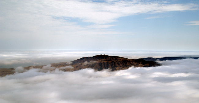 Aerial view of the high peak of Santa Cruz Island seen through a break in theclouds