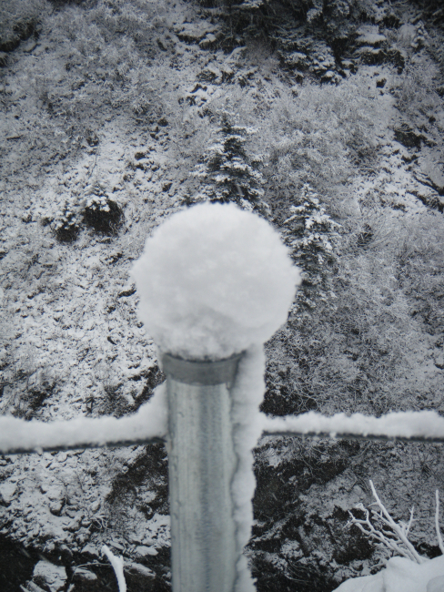 Freaks of the storm - a snowball forms atop a metal post