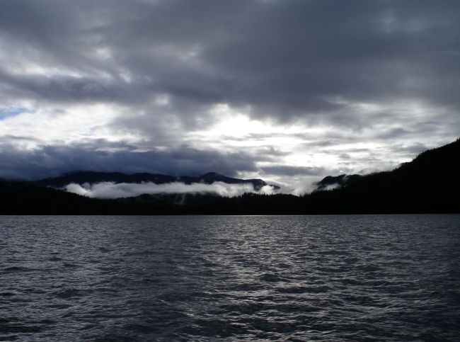 Clouds over head and fog filled valleys give a lead gray cast to Alaskan waters