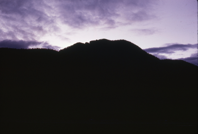 Clouds over a silhouetted mountain at days end