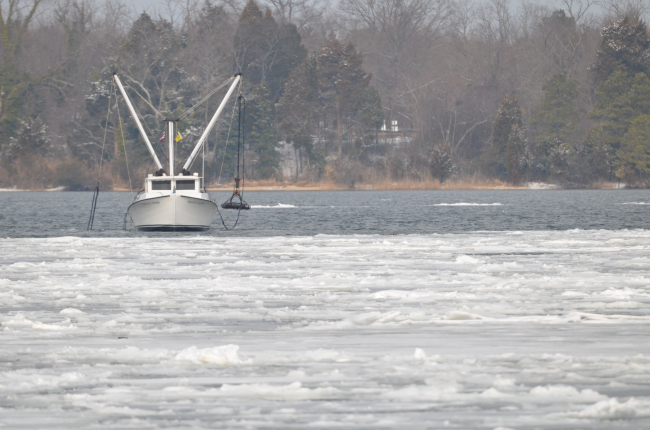 An oyster boat working the icy Patuxent River on a cold winter day