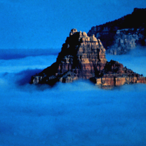 A rocky peak rises from a sea of fog in an Arizona valley