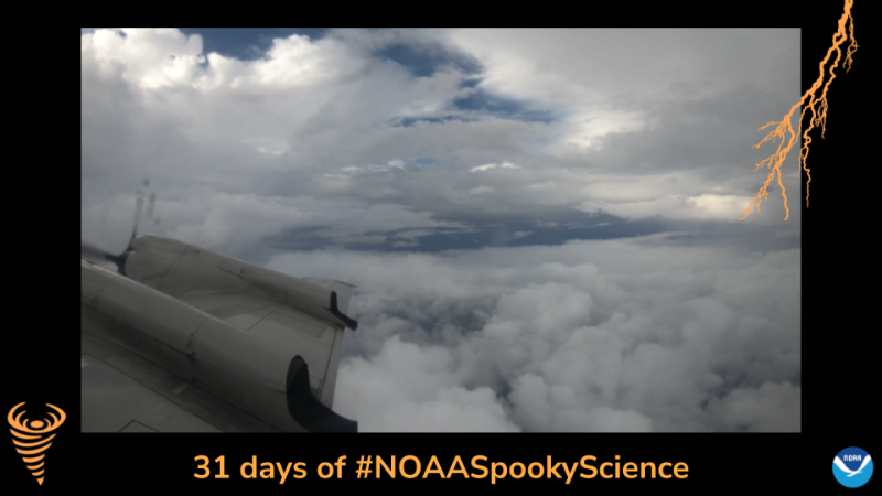 A view out the window of an airplane that shows the eye of Hurricane Henri. Border of the photo is black with orange atmospheric graphics of a lightning bolt and a tornado. Text: 31 days of #NOAASpookyScience.