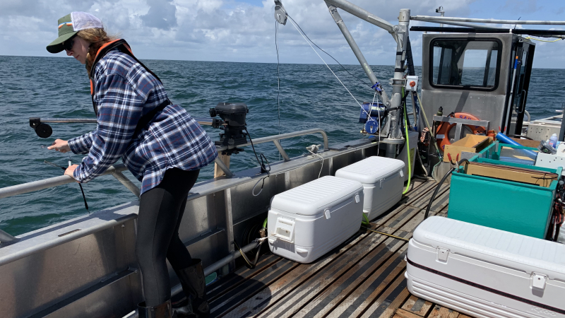 Raien Emery, a 2018 NOAA Hollings scholar, on the R/V Sailfin loading a downrigger with hooks targeted for juvenile salmon off the Washington Coast, June 4, 2019.