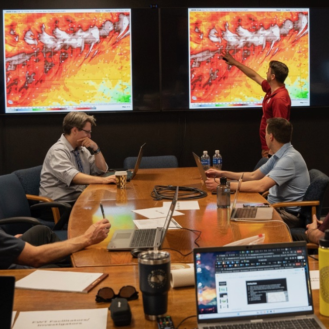 Kyle Thiem, with NOAA’s Global Systems Laboratory, highlights a high wind event in an upcoming simulation at the start of the final day of evaluating two new wildland fire decision support tools on large computer monitors in NOAA’s new Fire Weather Testbed
